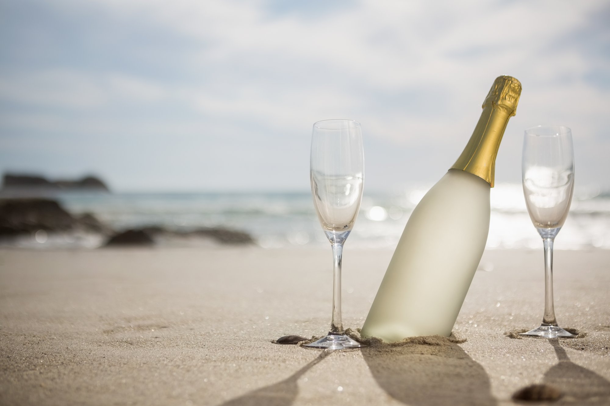 champagne-bottle-two-glasses-sand
